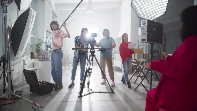 Behind the Scene Footage of a Commercial: Film Crew Working Together to Shoot an Aesthetic Video as Marketing Content. Dynamic Zoom Out Catching the Positive Energy of Young Video Creators