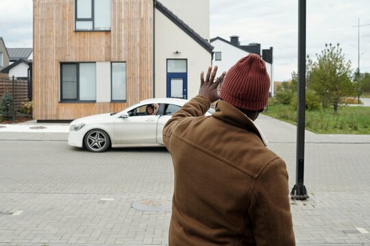 Mature man saying goodbye to woman leaving for work by car