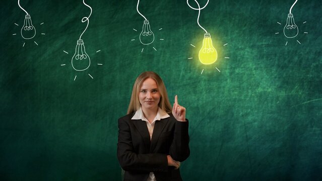 Portrait of woman isolated on green background light bulbs image on top. Joyful girl pointing to a glowing light bulb as a symbol of a bright idea.