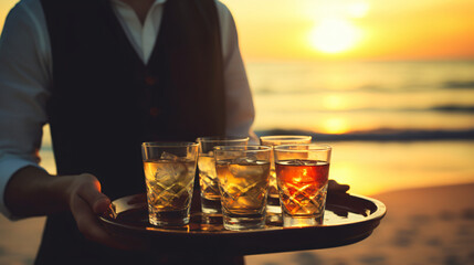 The waiter serves glasses of alcohol on a tray - obrazy, fototapety, plakaty