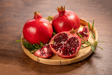 Pomegranate on wooden basket on wooden background, Pomegranate with slices on wooden Background.