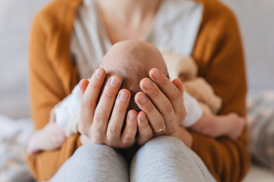 Mother holding newborn son in hands at home