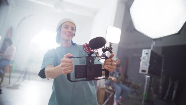 Slow Motion Portrait of Cinematographer Working On a Filming Set, Using Mobile Smartphone Rig to Shoot High-Quality Footage for Cinematic Project. Creative Artist Operating Modern Cinema Equipment