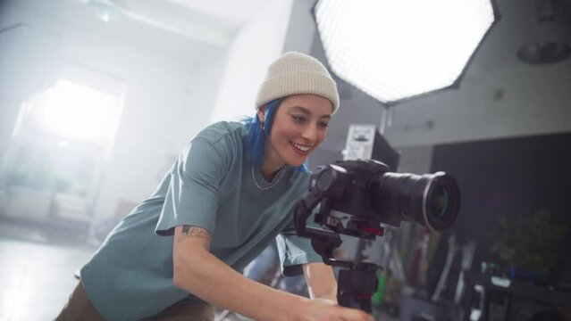 Slow Motion Portrait of a Female Videographer Using a Stabilizer on a Set and Following Instructions from Director While Filming a Commercial. Artist Using Digital Camera For Making a Creative Video