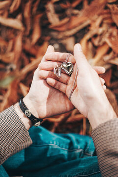 Man holding heart shaped necklace in hand