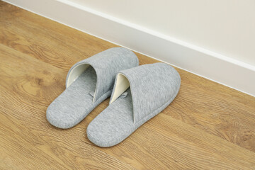 Gray slippers on the floor by the bed