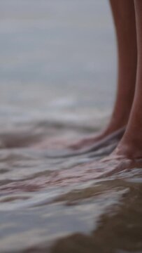 Woman feet on sunset beach, wet by seawater at sunset golden hour. Concept, well-being, health, and tranquility. Well-being, contact with nature and full awareness in the sea.