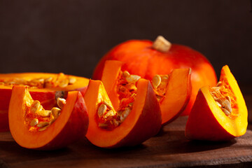 A sliced orange pumpkin on a dark background