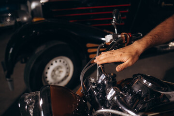 Fototapeta na wymiar A man is holding the steering wheel of his retro motorcycle