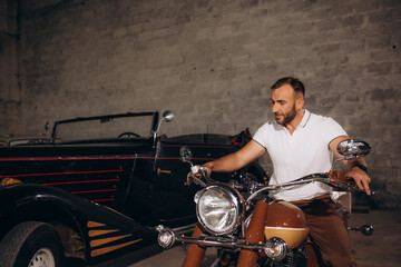 Fototapeta na wymiar A man collects retro motorcycles and retro cars in his garage
