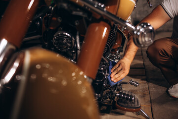 A man washes his retro motorcycle