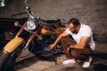 A man collects retro motorcycles and retro cars in his garage - obrazy, fototapety, plakaty