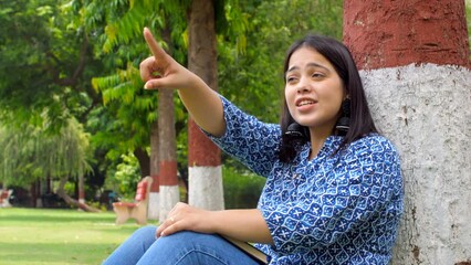 Energetic Indian woman talking with friend on video call - virtual conversation  chatting with friend  gossiping . POV of tourist receiving directions - interacting with a talkative Asian girl