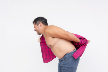 An overweight man struggles to put on an undersized polo shirt that used to fit him. A shirt too...