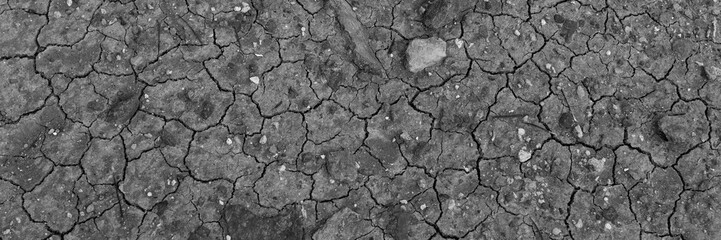 Black dry earth background. Cracked ground. Global warming. Panorama