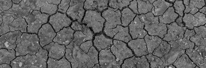Black dry earth background. Cracked ground. Global warming. Panorama