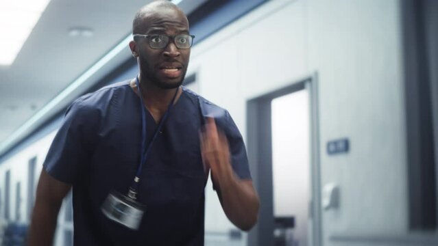 Emergency in the Hospital: Male Doctor or Nurse Running through the Hallway, in a Hurry to Save Lives. Black Young Healthcare Professional Reporting for Duty, Hurrying to Help his Patient