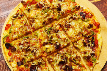 St. Louis-Style Pizza homemade on a wooden background, with cheese, pepper, bacon onion