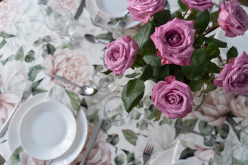 Table setting in the living room. Flowers in a vase on the table. Table decor for the arrival of guests.