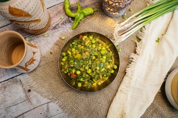 Spring Onion Potatoes Vegetable in the bowl over wooden table, Pyaaz Ki Sabzi Recipe, Fresh Mixed Vegetables Green Peas and Onion Close Up, Rajasthan Special.