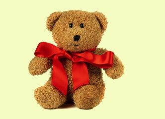 Toy fluffy vintage bear with a red bow on a retro background. Children's cute soft toy.