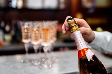 waiter hand open champagne wine bottle