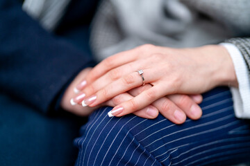 close-up of a man and a woman hand in hand.