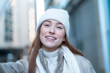 portrait of smiling young woman  having a fun time in Christmas market , using phones at outdoor in...