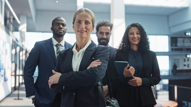 Group of Happy Multiethnic Team of Female and Male Managers, Specialists and Business Professionals Posing for Camera and Smiling. Portrait of a Confident Female Team Leader Standing First