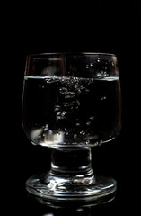 Clean water in a glass on a black background