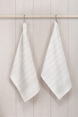 Kitchen towels hanging on wooden background