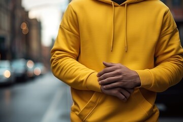 Front view of an unidentifiable person standing on a city street wearing a plain hoodie, mockup