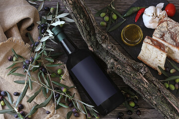 Olive oil, bread and olives on rustic wooden background