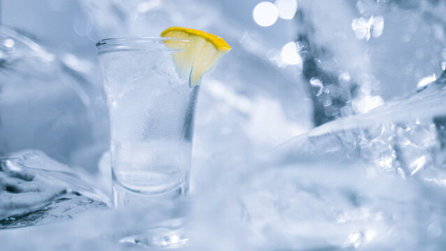 A glass of vodka with ice and lemon