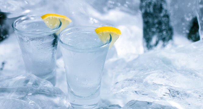 Two glasses of vodka with ice and lemon