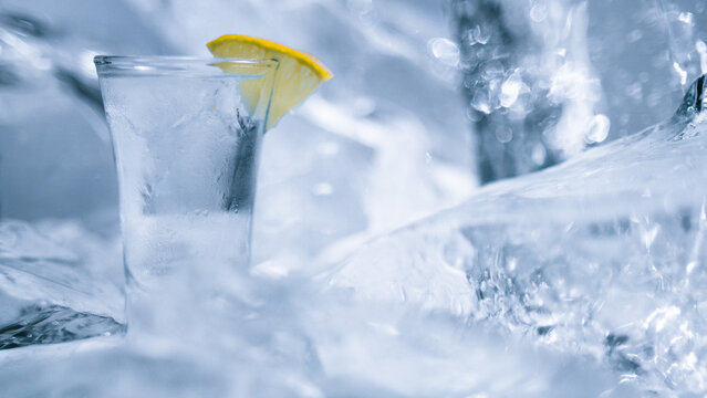 A glass of vodka with ice and lemon
