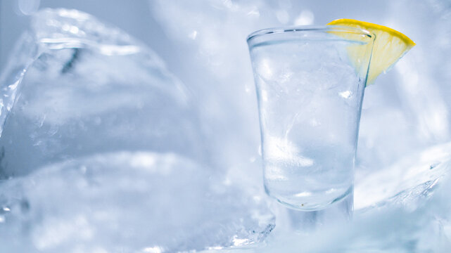 A glass of vodka with ice and lemon
