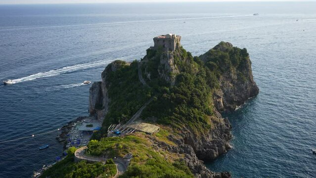Scenic top view from mountain on Stone Tower on rocky Coast with blue sea. Torre Capo di Conca - historical landmark on Conca dei Marini, Amalfi Coast, Italy, Europe. Shooting in slow motion.