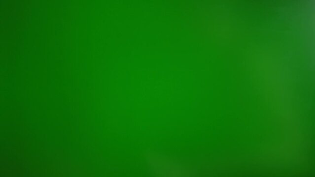 A man makes a fig with his fingers on a green background. The concept of resistance and contempt