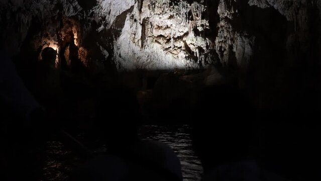 View from floating ship to Grotta dello Smeraldo just outside Amalfi, natural highlight along Amalfi Coast. Light from flashlight brightens dark interior of cave. Shooting in slow motion.