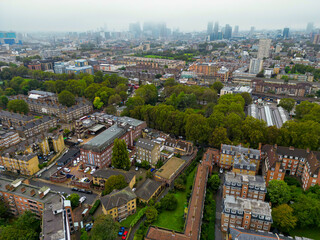 Fototapeta premium Top cinematic aerial view to the London streets. Drone footage. Flight over London - amazing view over the rooftops - travel videography. Establishing Aerial View Shot of London UK, United Kingdom