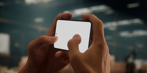 CU Caucasian male worker using smartphone inside huge warehouse