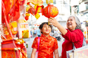 Happy Asian family grandmother and grandchild girl in red dress choosing and buying home decorative...