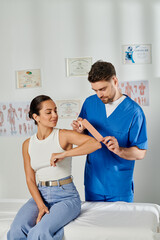 Obraz premium young woman in casual attire watching how doctor putting kinesio tapes on her elbow, healthcare