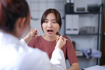Asian dentist doctor women using explorer mirror tool to examining teeth of patient and explaining about oral dental treatments while discussion about dental health and healthcare in dental clinic - obrazy, fototapety, plakaty