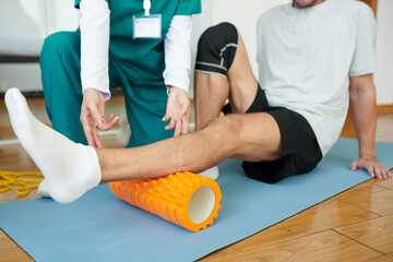 Patient or rehabilitation center using myofascial roll to release muscle tension in calf