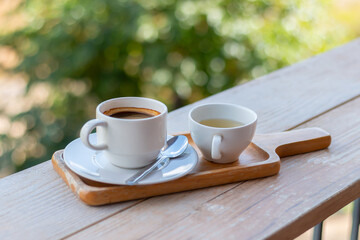 Wooden tray to hold empty coffee, coffee and water in a coffee shop.Hot black espresso coffee in the cup