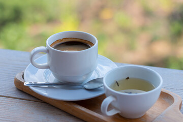 Wooden tray to hold empty coffee, coffee and water in a coffee shop.Hot black espresso coffee in the cup