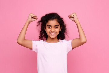 indian girl standing on pink background and showing arms muscles