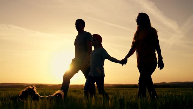Happy family concept.silhouettes of group of people with dog at sunset outdoors. picnic in park. family day. family vacation in nature. active weekend outdoors with dog. family day at sunset in park